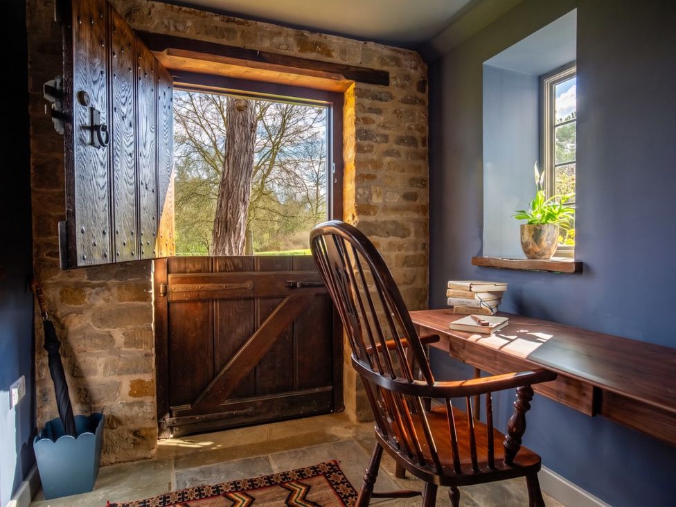 An office with a wooden chair and a desk beside an open door at the property in 