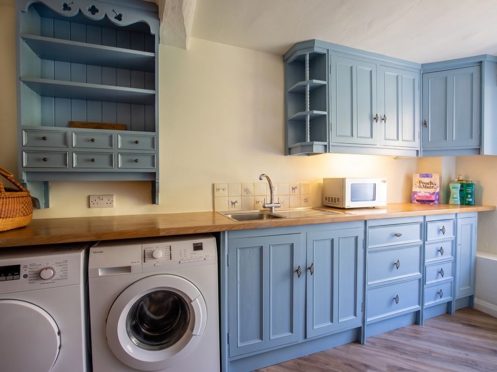 A kitchen with cabinets, a sink, a washing machine, and a microwave at the property in 