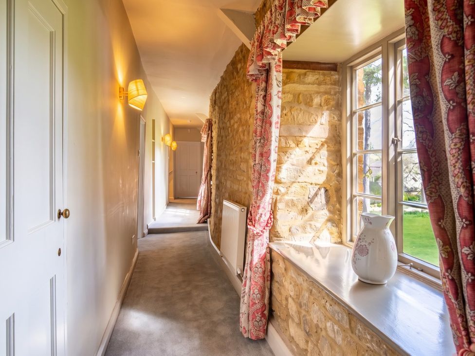 A hallway with a window and a radiator at the property