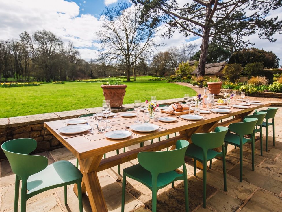An outdoor dining area with a long table set for a meal at The Old Barn in Manchester