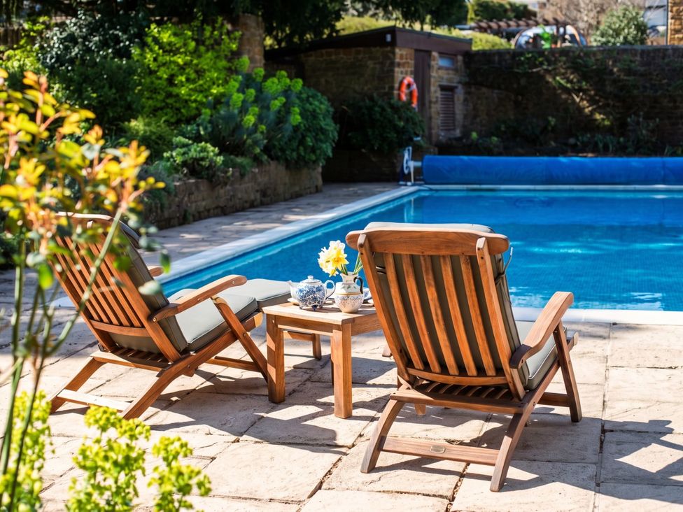 An outdoor area with deck chairs and a table beside a swimming pool at 