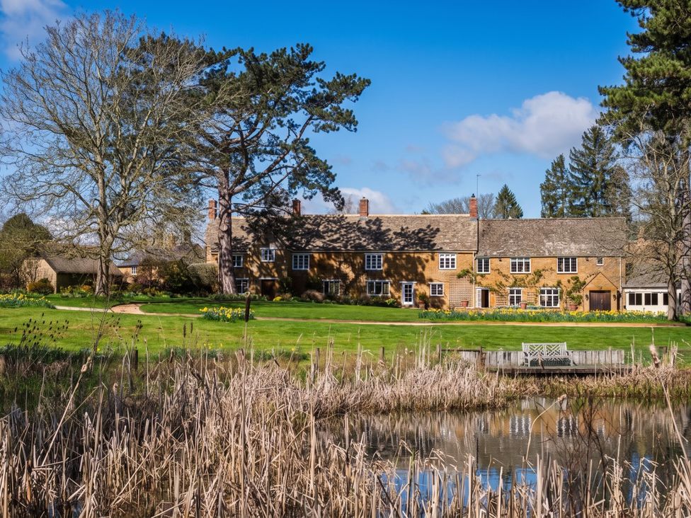 A house with trees and a pond in the foreground at a property