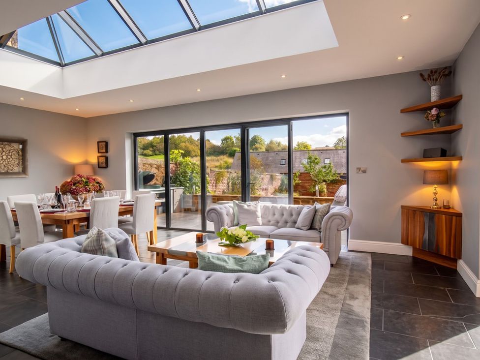 A living room with a sofa and dining area at The Old Barn in Manchester