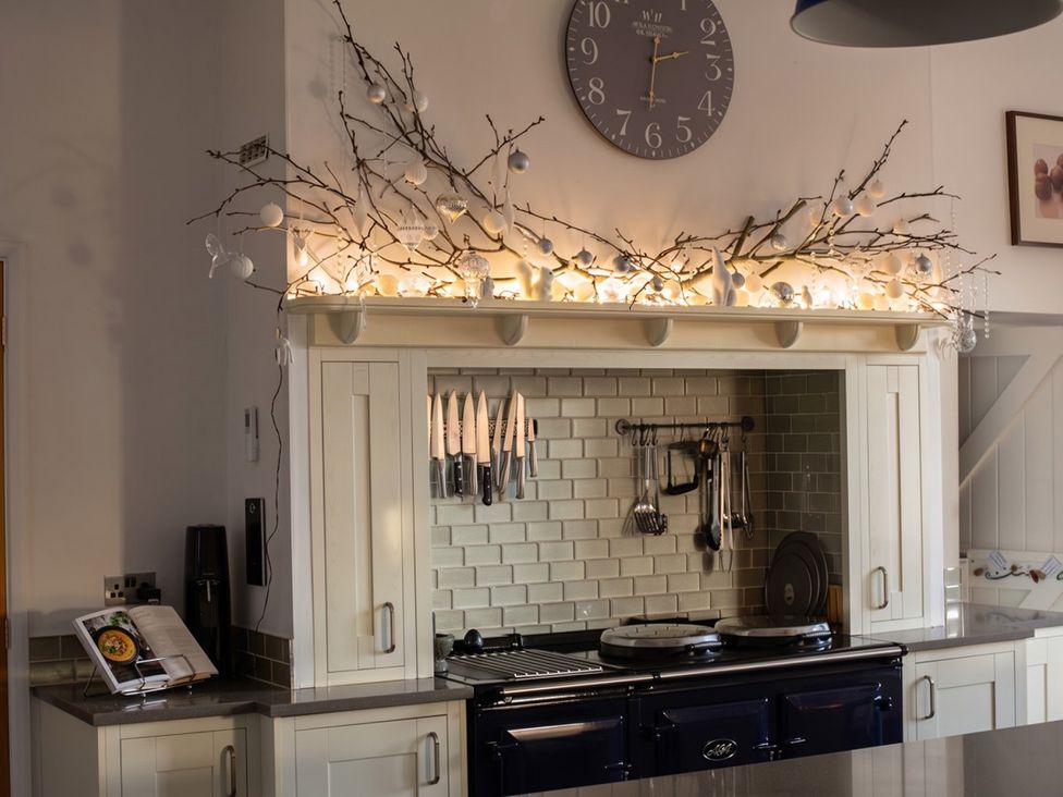 A kitchen with a clock and utensils on a kitchen unit at The Old Barn in Manchester