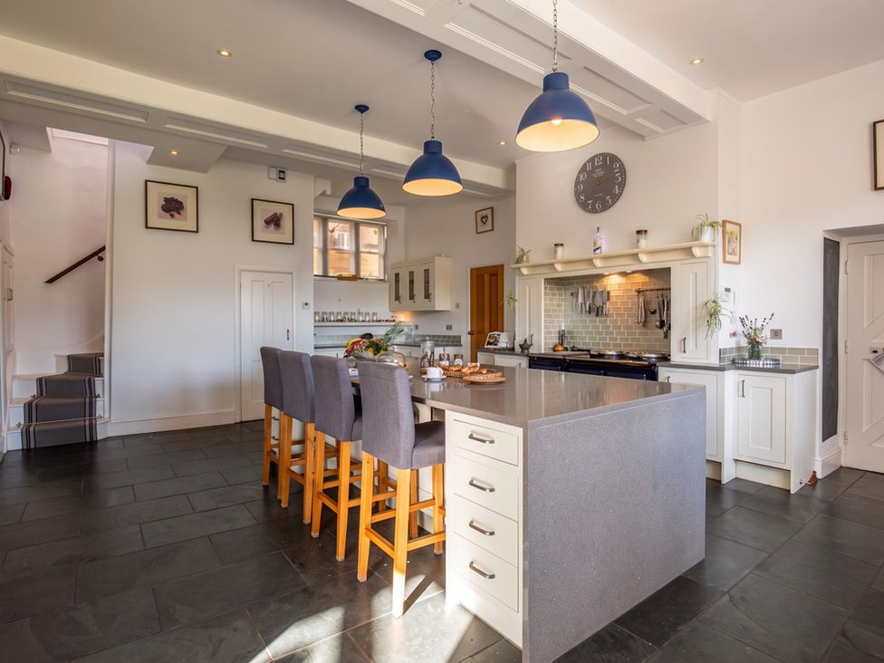 A kitchen with a central island and bar stools at a property