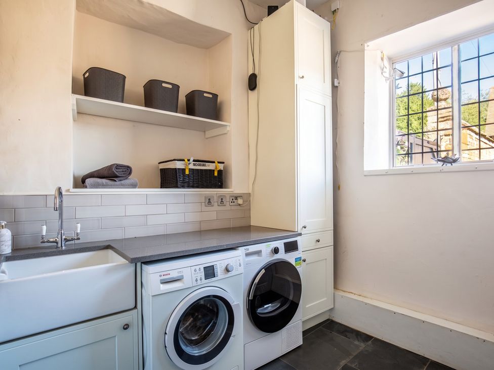 A laundry room with washing machine and tumble dryer at the property in 