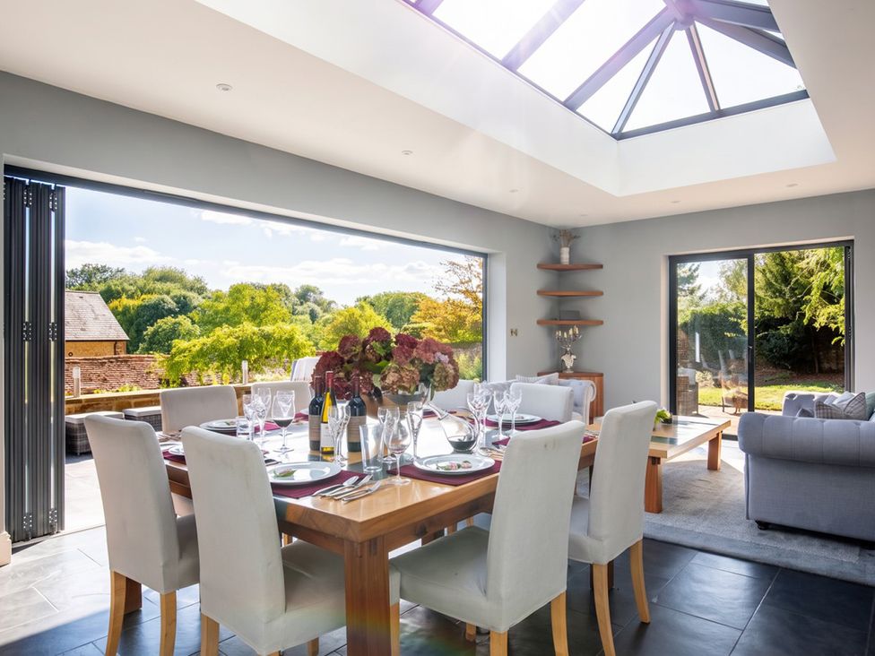 A dining room with a large table and windows at the property in 