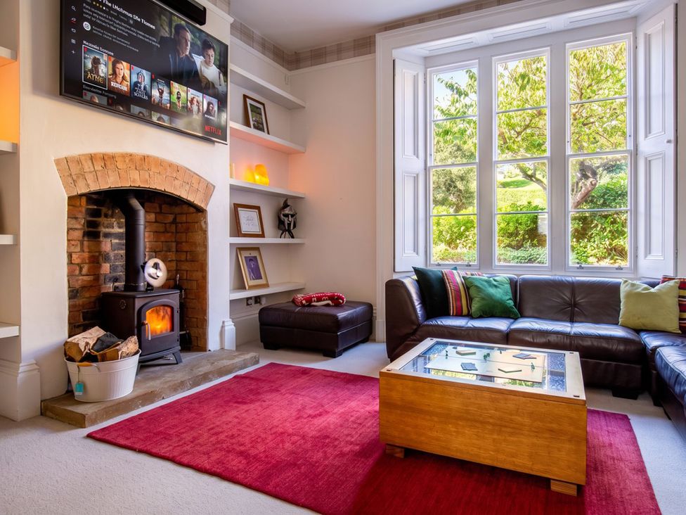 A living room with a fireplace and a television at a property