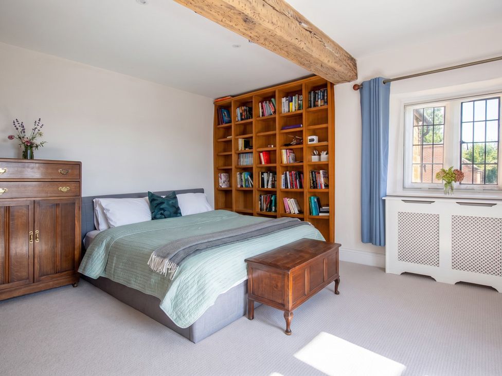 A bedroom with a bed and bookshelf at a property