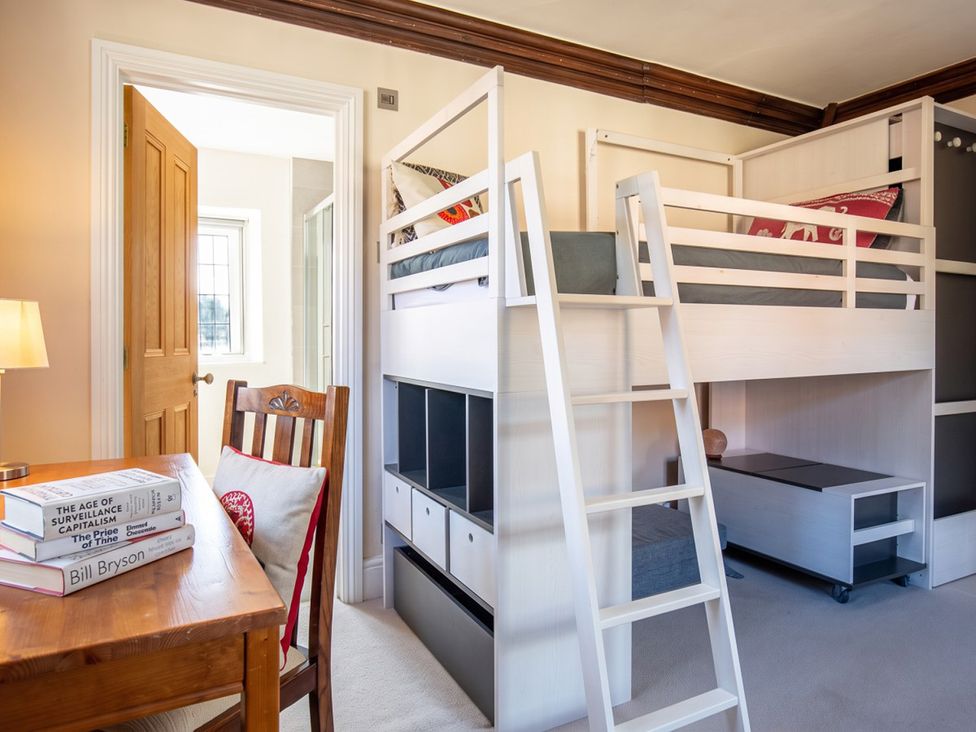 A bedroom with a loft bed and a study area at The Old Barn in Manchester