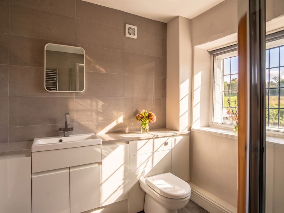 A bathroom with a sink, toilet, and window at 