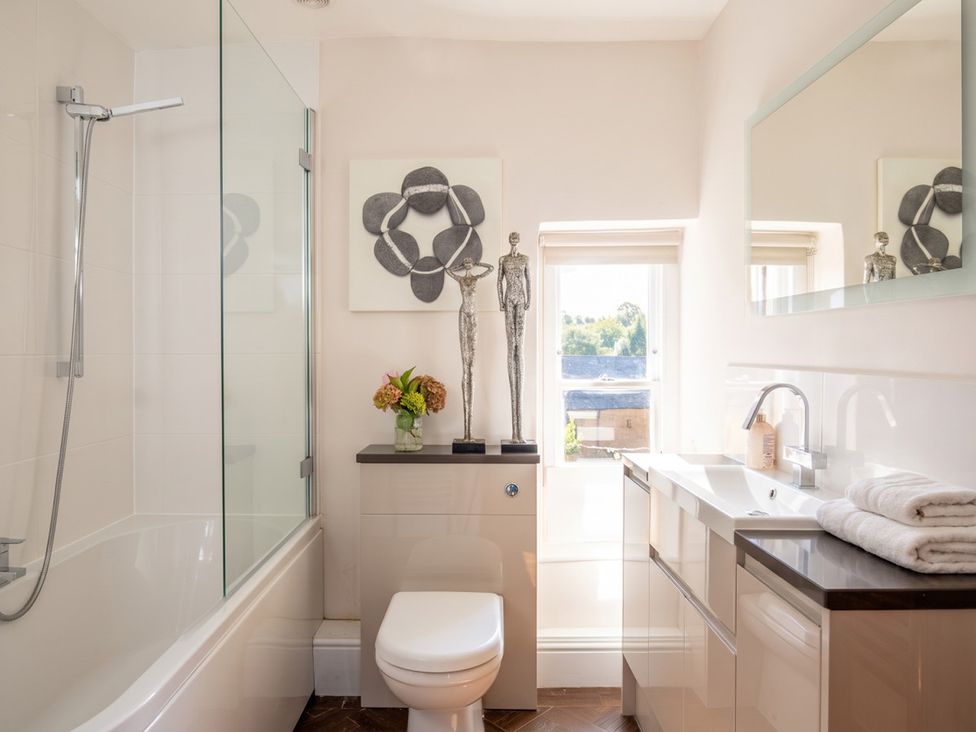 A bathroom with a shower, sink, and decorative elements at The Old Barn in Manchester