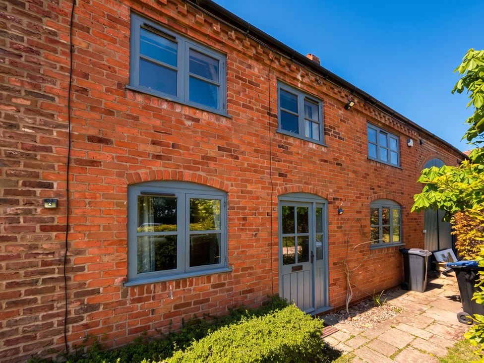 An exterior view of a brick house with windows and a door at The Old Barn in Manchester