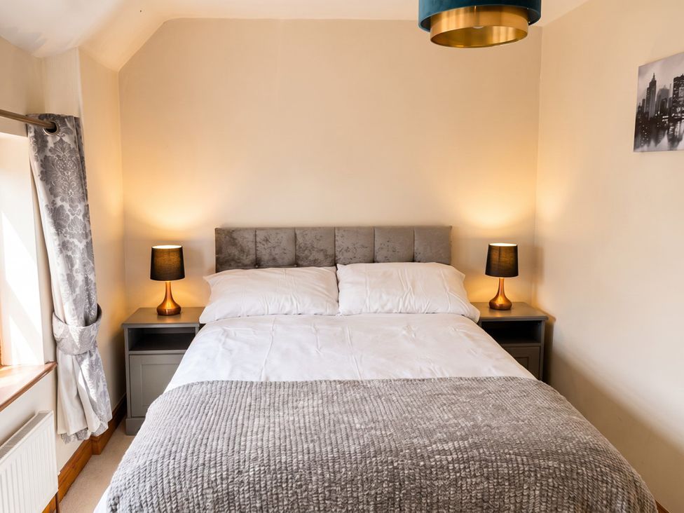A bedroom with a bed and bedside tables at The Old Barn in Manchester
