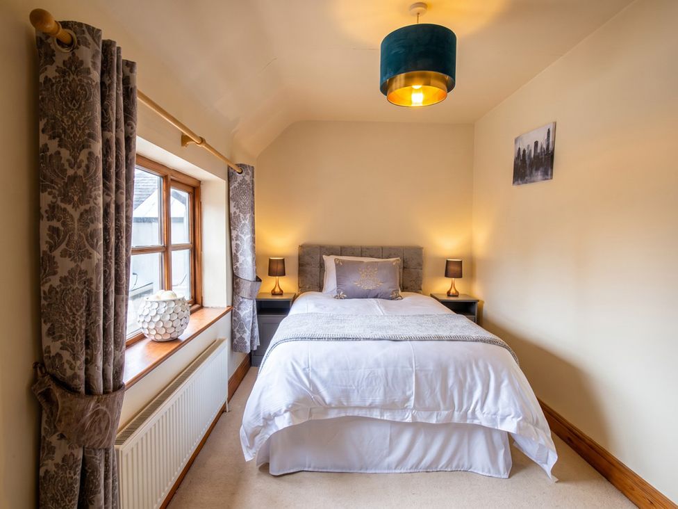 A bedroom with a bed and nightstand at The Old Barn in Manchester