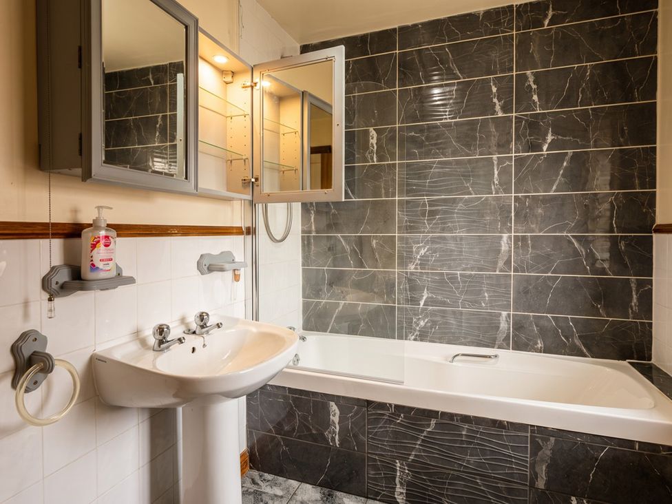 A bathroom with a bathtub and sink at The Old Barn in Manchester