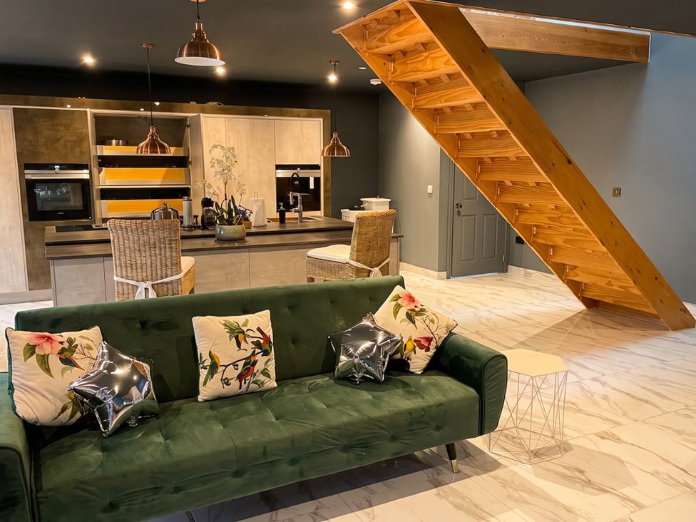 A kitchen with a sofa and stairs at the property