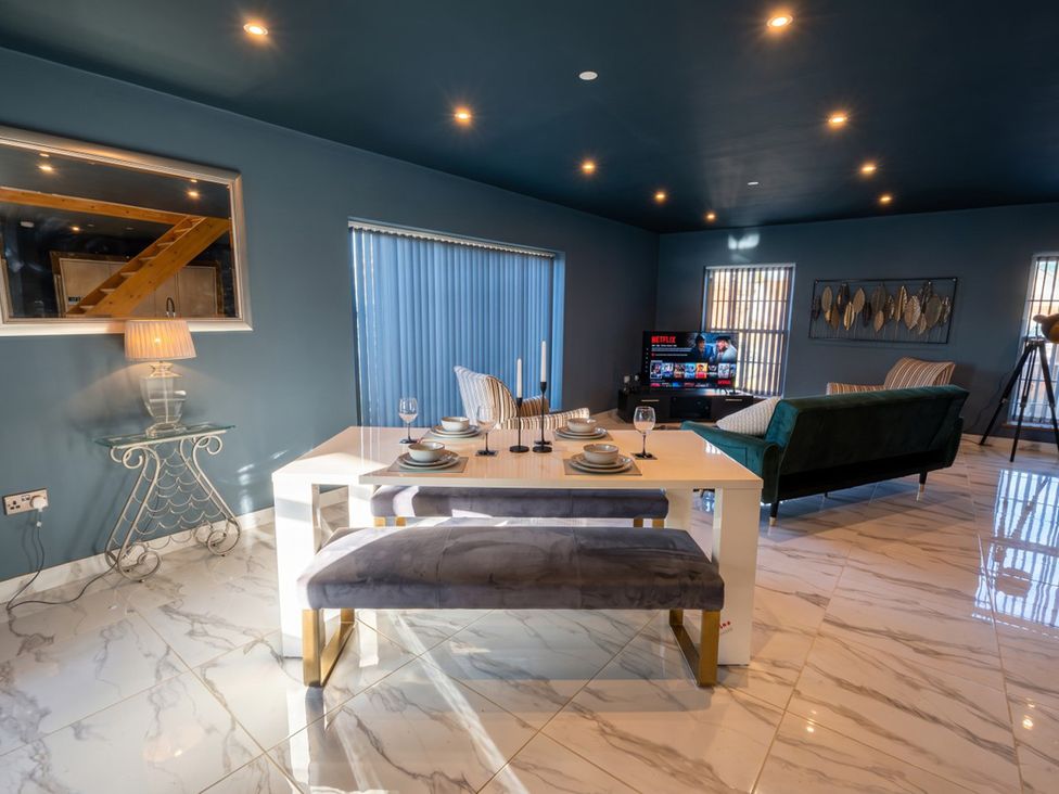 A dining room with a table and bench in front of a sofa at the property