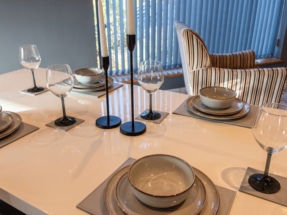 A dining table set with plates and glasses at a modern property