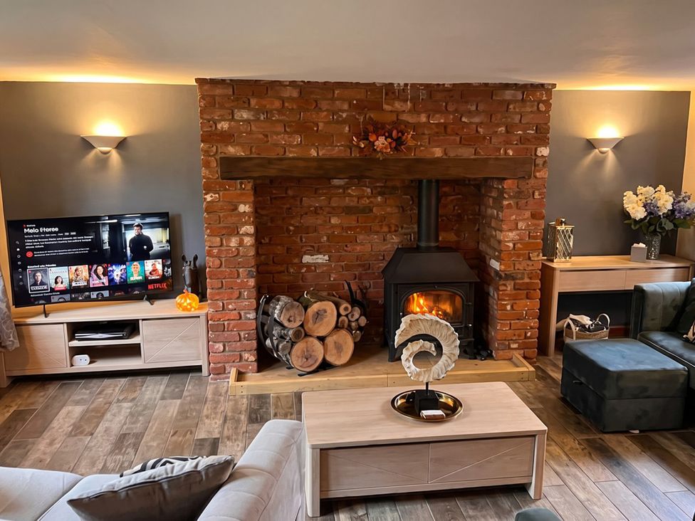 A living room with a fireplace and television at The Old Barn in Manchester