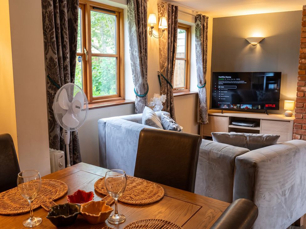 A living room with a television and dining table at The Old Barn in Manchester
