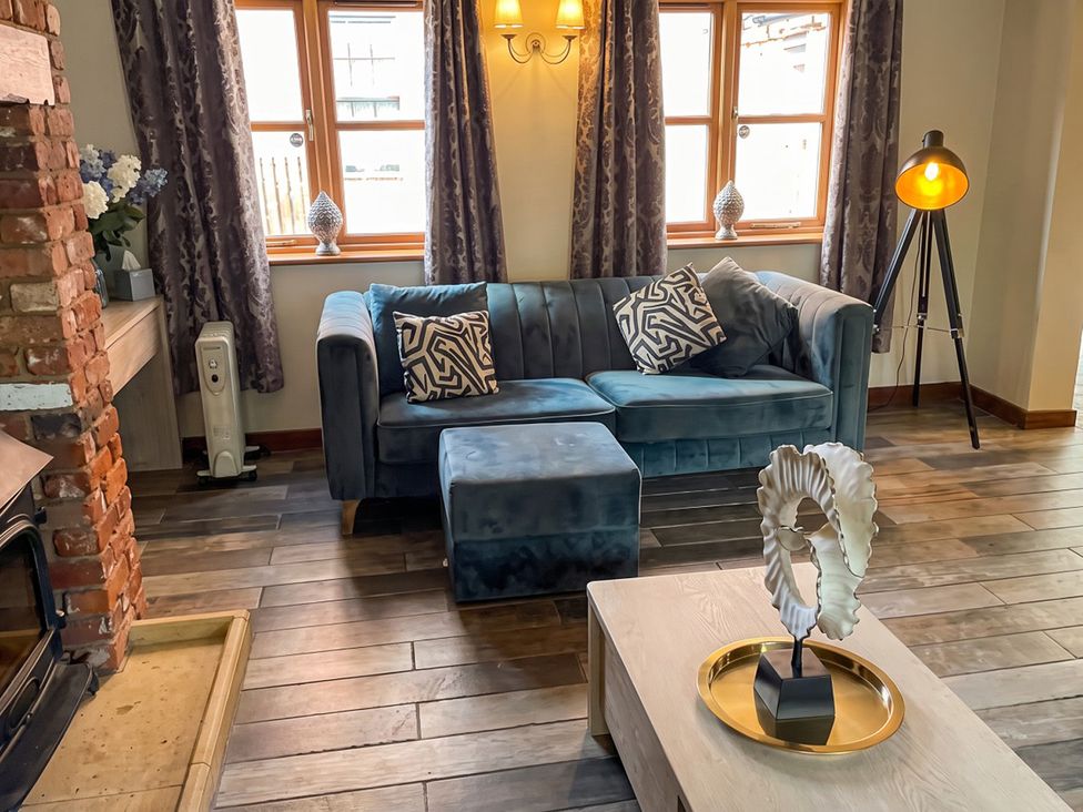A living room with a sofa, coffee table, and sculpture at The Old Barn in Manchester