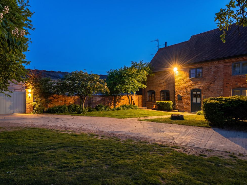A brick house with trees and a garage in the outdoor area