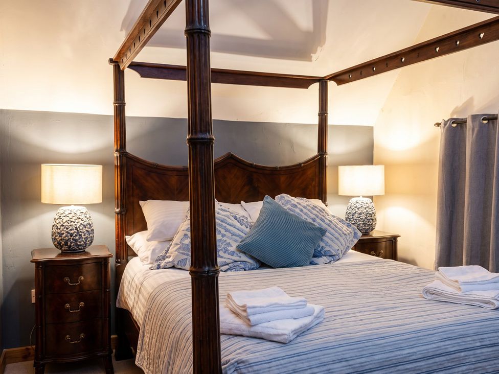 A bedroom with a four-poster bed and bedside tables at The Old Barn in Manchester