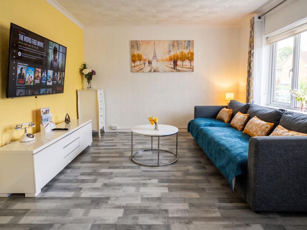 A living room with a television and sofa at The Old Barn in Manchester
