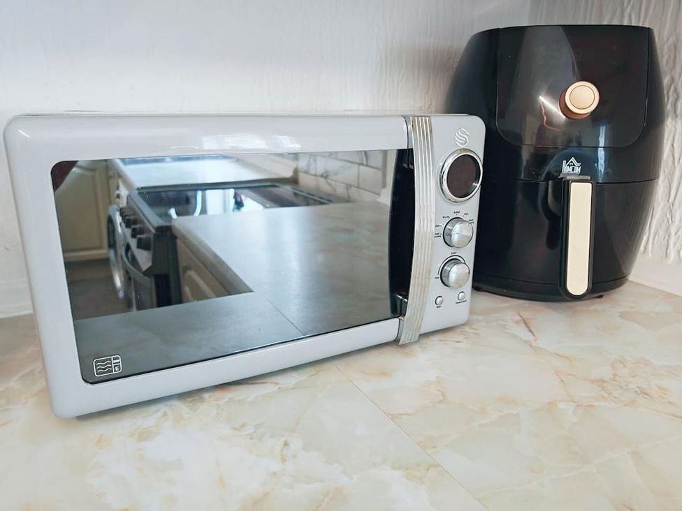 A microwave and air fryer on a kitchen countertop at an unspecified location