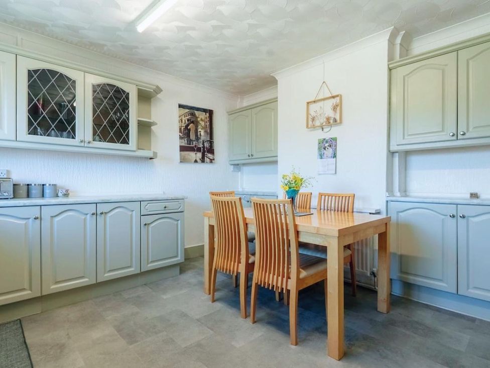 A kitchen with cabinets and a dining table at 