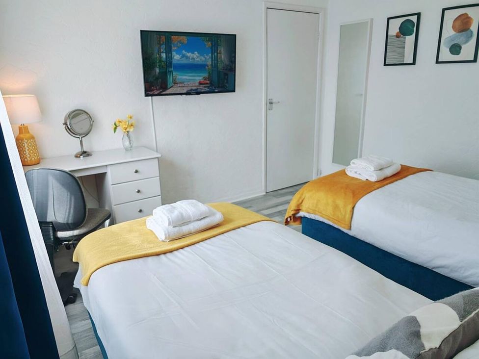 A bedroom with two beds, a desk, and a television at the property in the location