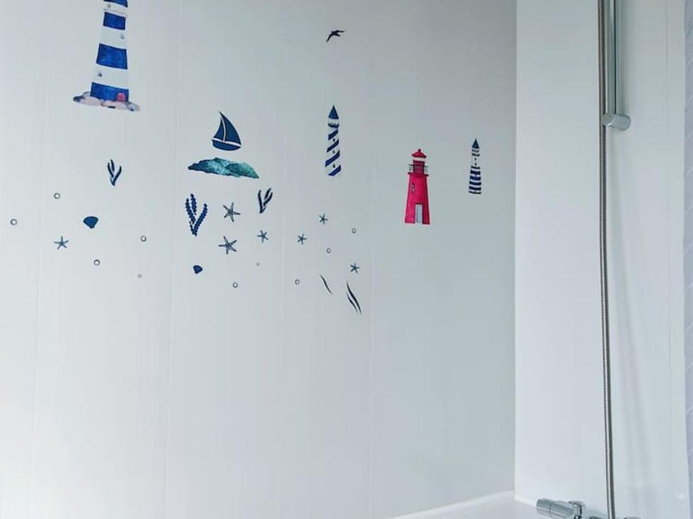 A bathroom with nautical wall decals and a shower at a property