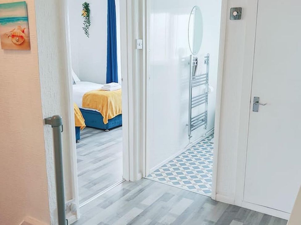 A hallway leading to a bedroom with a bed and towel at The Old Barn in Manchester