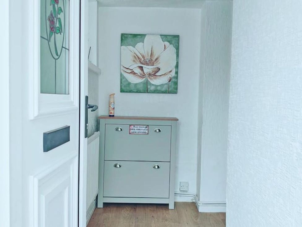 A hallway with a drawer unit and a flower painting at the property in 