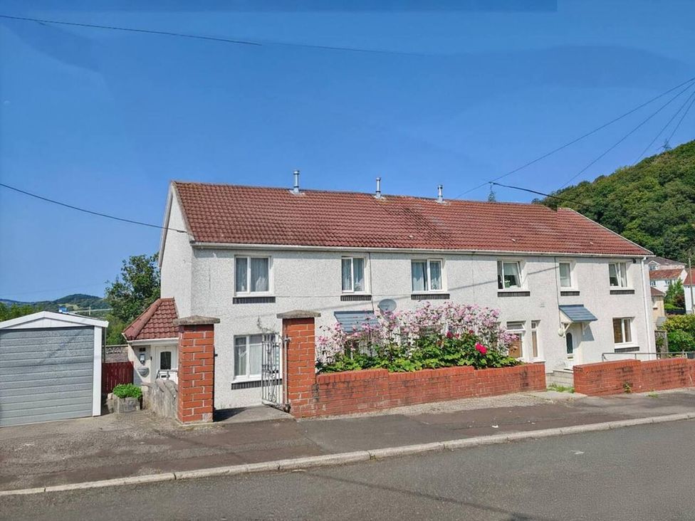 A house with a garden and garage on a street
