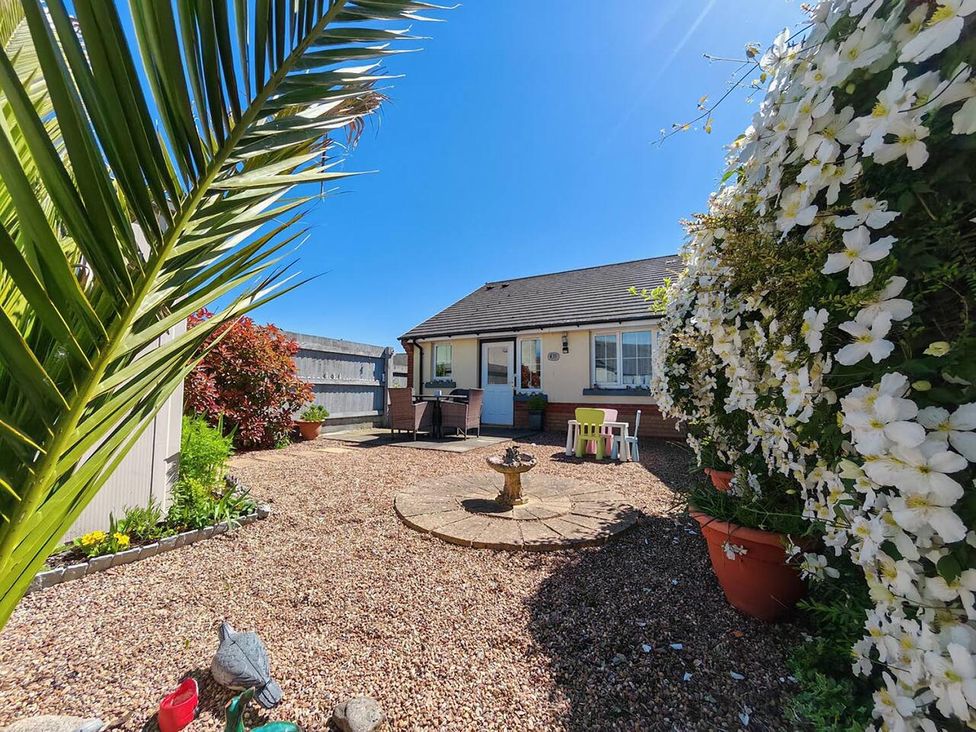 A garden with a fountain and seating area at The Cottage in Unknown