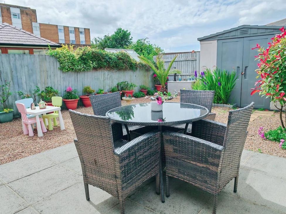 A garden with a table and chairs and plants at The Old Barn in Manchester