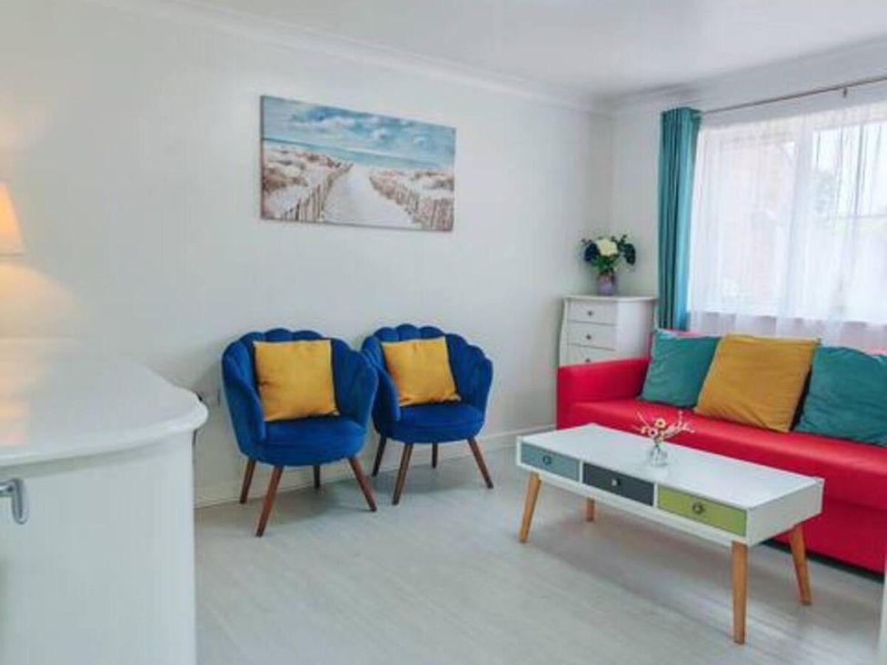 A living room with a red sofa and blue armchairs at 