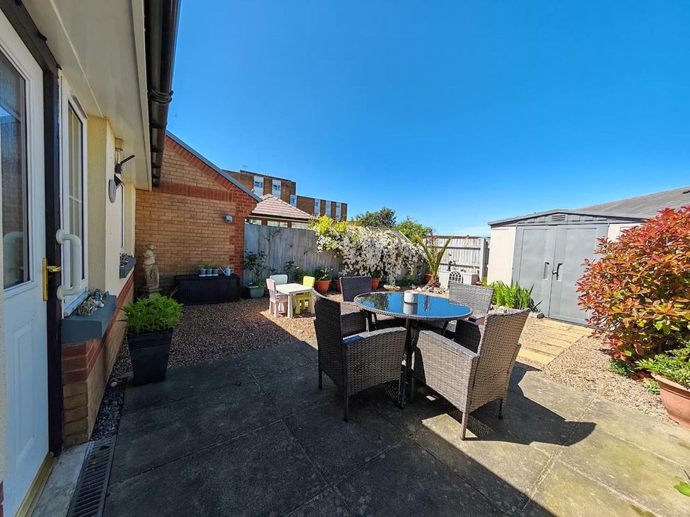 A garden with a table and chairs at a property in a residential area