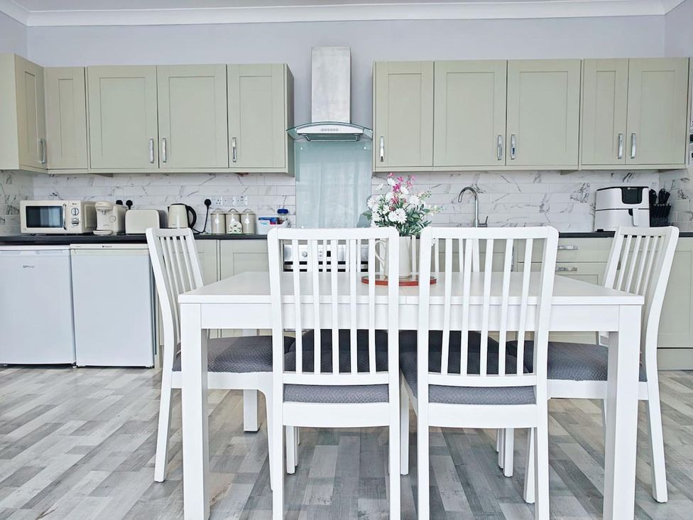 A kitchen with a dining table and chairs at the property in location