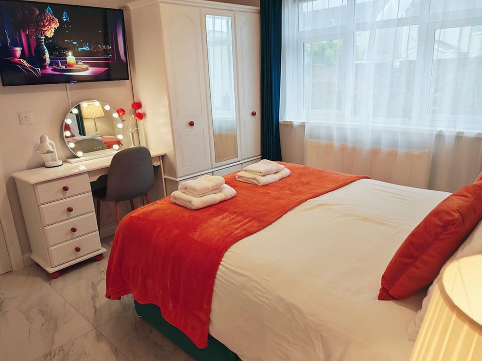 A bedroom with a bed and wardrobe at The Old Barn in Manchester