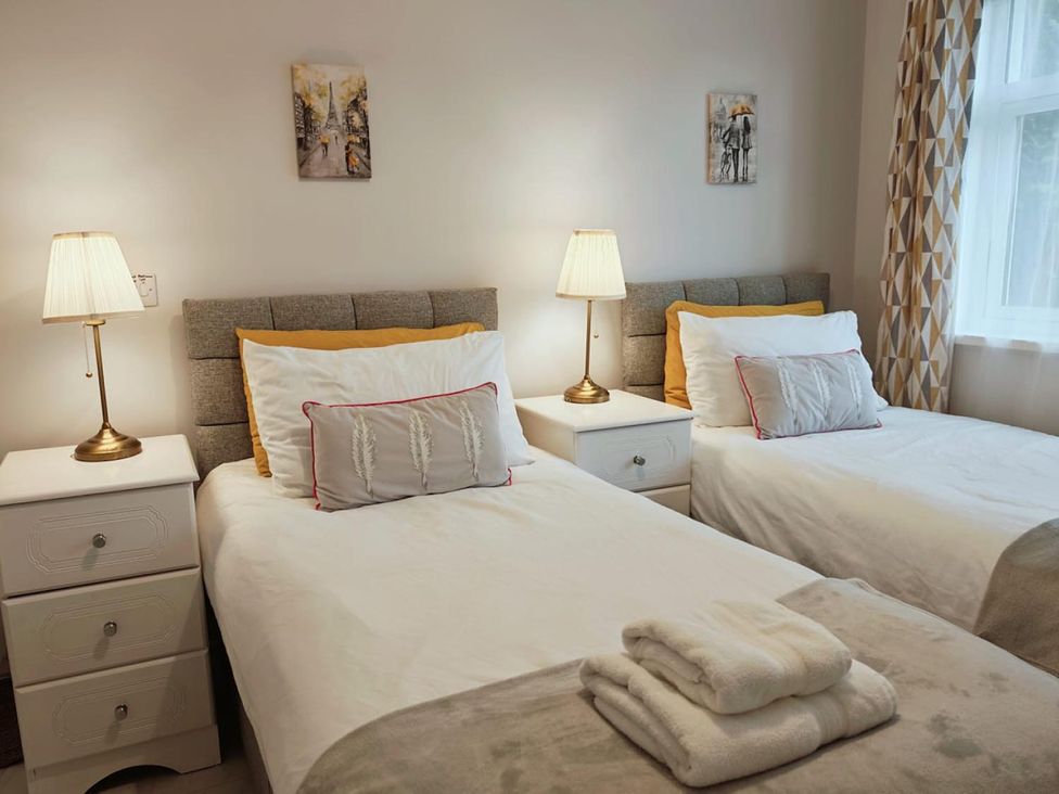 A bedroom with two beds and bedside lamps at The Old Barn in Manchester