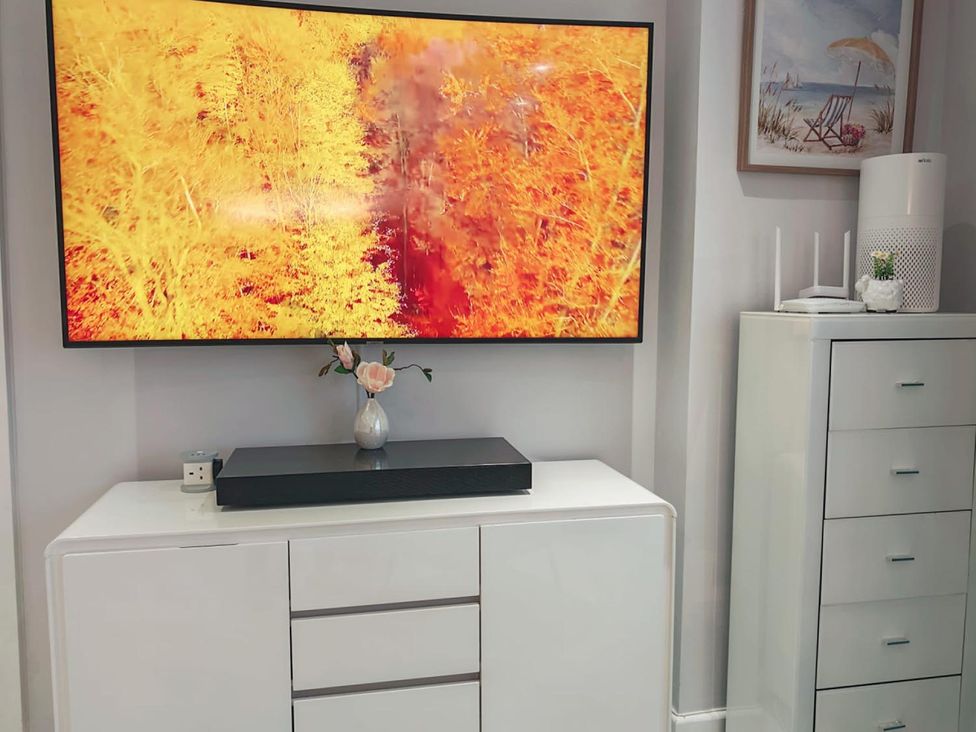 A living room with a television and a media console