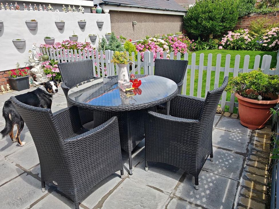 A garden with a table and chairs and flowers at 