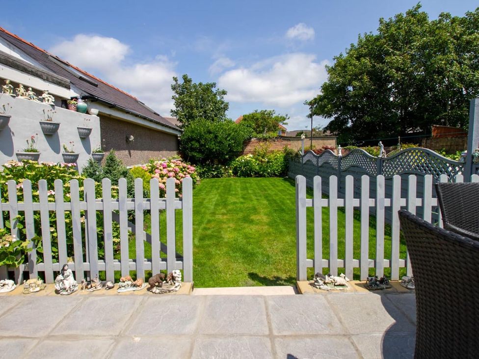 A garden with a lawn and flowers at The Old Barn in Manchester