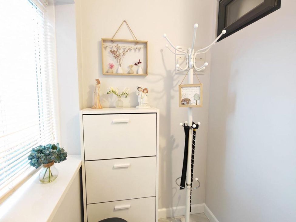 An entrance with a coat rack and storage cabinet