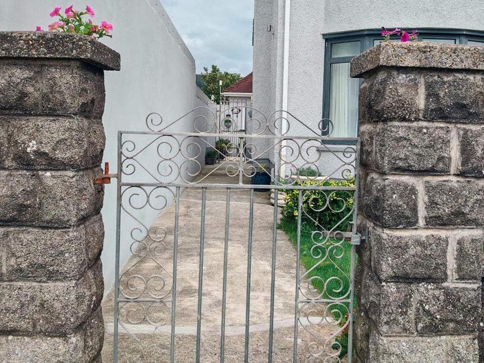An outdoor pathway with a decorative gate in a garden at The Old Barn in Manchester