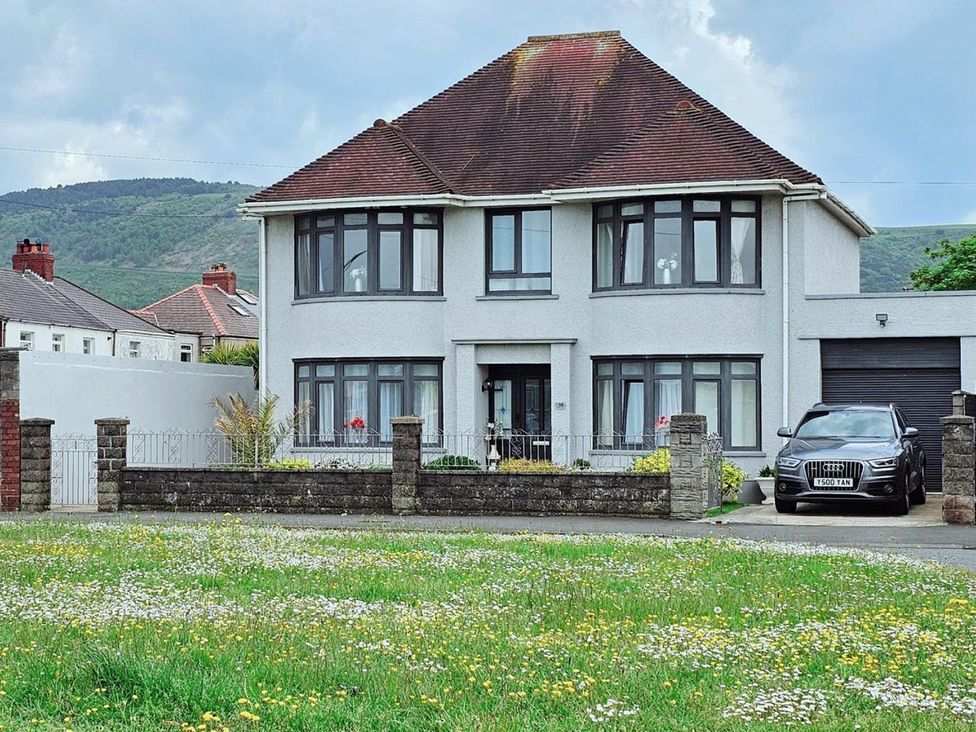 A house with a garden and a car parked outside