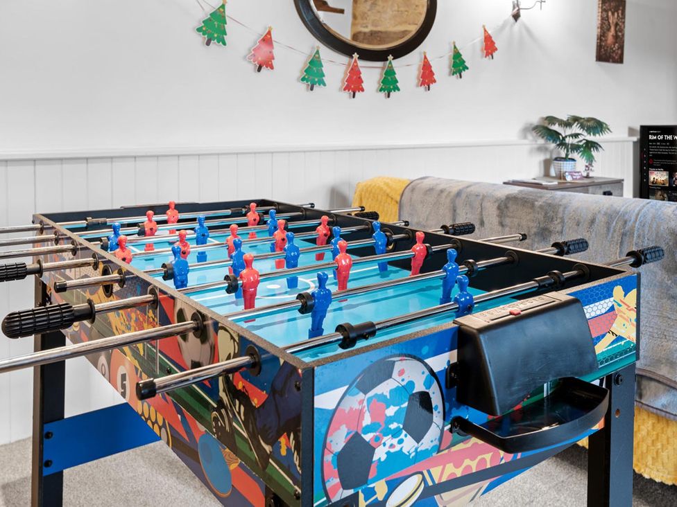 A foosball table with blue and red players in a game room